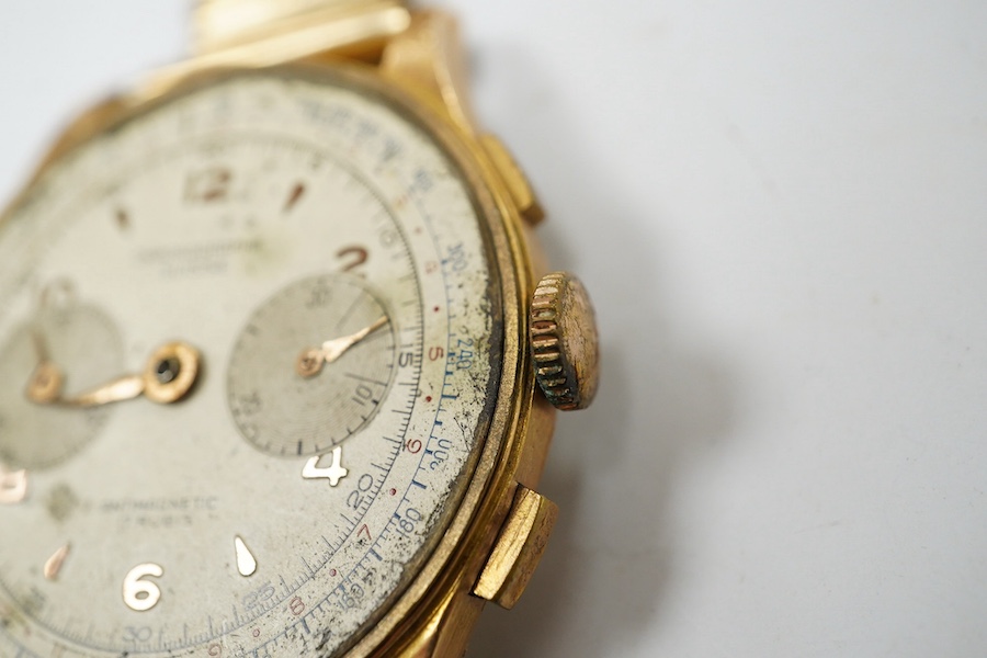 A gentleman's yellow metal Swiss chronograph manual wind wrist watch (lacking back cover), on a gold plated strap. Condition - poor.